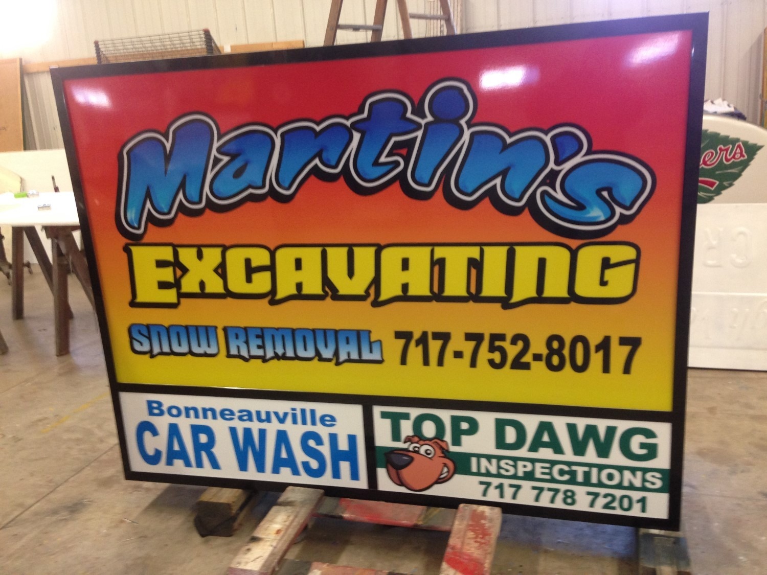 Sign for Martin's Excavating, snow removal, Bonneauville Car Wash, and Top Dawg Inspections with contact numbers.