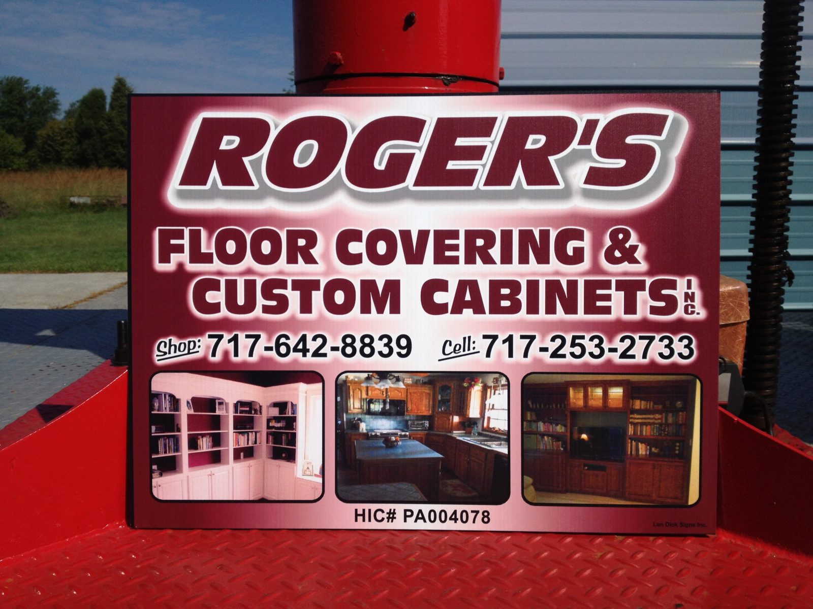 Sign for Roger's Floor Covering & Custom Cabinets with contact numbers and photos of flooring and cabinetry work.