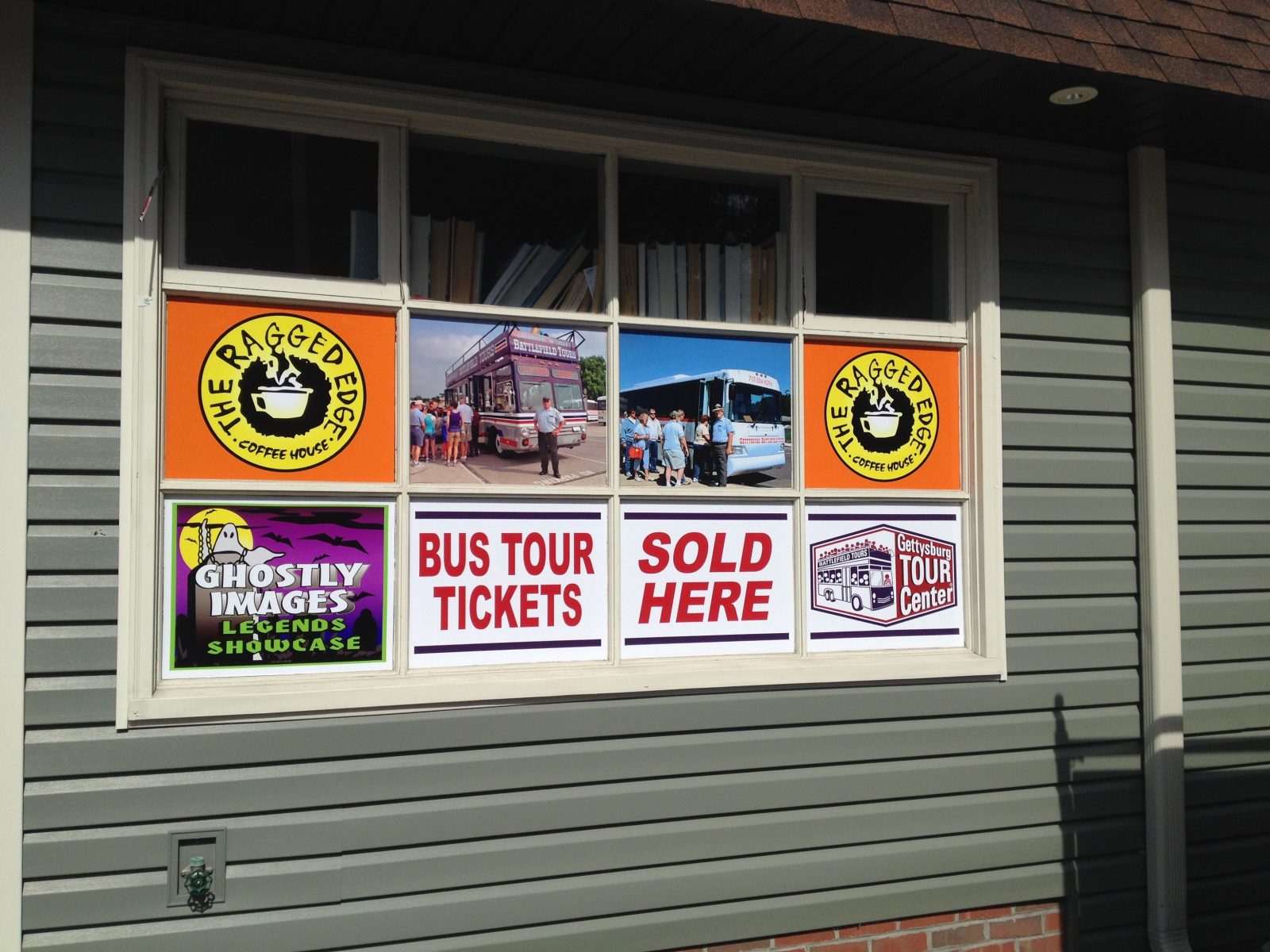 A window displays signs for The Ragged Edge coffee, bus tour tickets, and the Ghostly Images Legends Showcase.