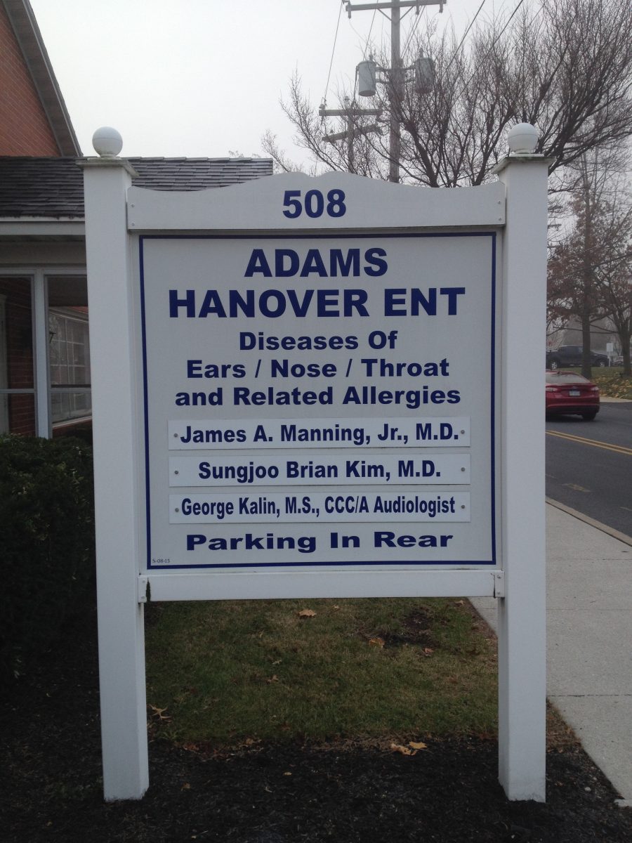 Sign for Adams Hanover ENT listing doctors and services offered, with parking information at 508 address on a street.